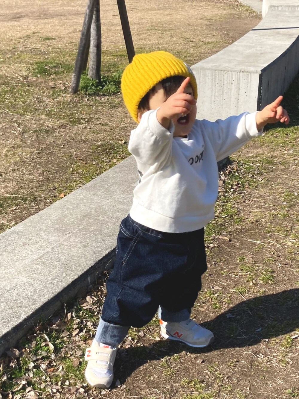 グリーン系のダウンジャケット/コート、ホワイト系のスウェット、ブルー系のデニムパンツを着用したキッズの冬コーディネートの3枚目の写真