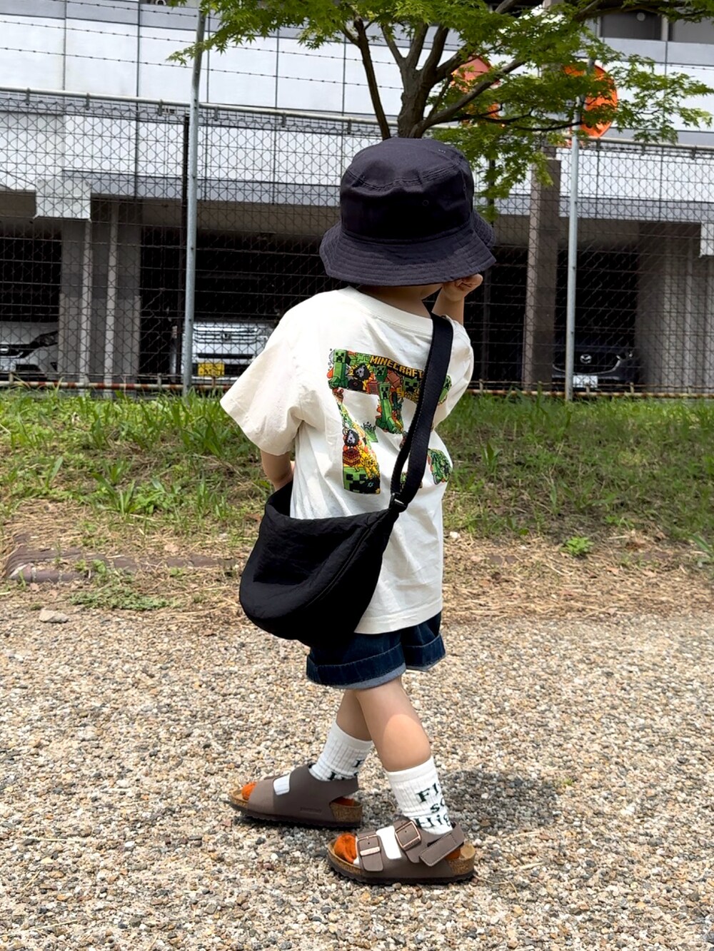 ホワイト系のTシャツ/カットソー、ブルー系のデニムパンツ、ブラック系のショルダーバッグを着用したキッズの夏コーディネートの4枚目の写真