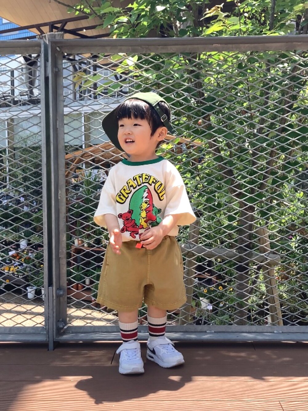 グリーン系のTシャツ/カットソー、イエロー系のその他パンツ、ホワイト系のスニーカーを着用したキッズの春コーディネートの2枚目の写真