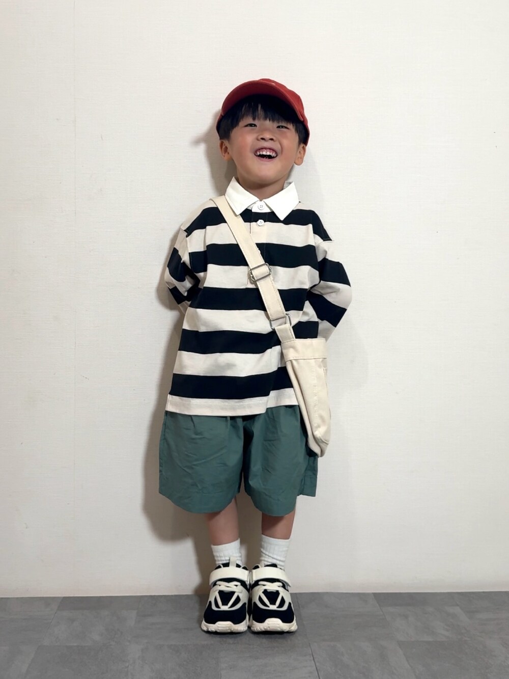 グリーン系のその他パンツ、ホワイト系のショルダーバッグ、ホワイト系のポロシャツを着用したキッズの夏コーディネートの3枚目の写真