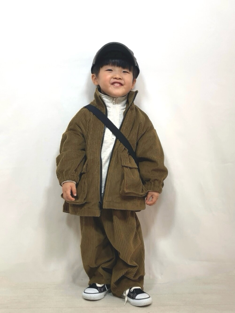 グリーン系のブルゾン、グリーン系のその他パンツ、ブラック系のメッセンジャーバッグを着用したキッズの冬コーディネートの4枚目の写真