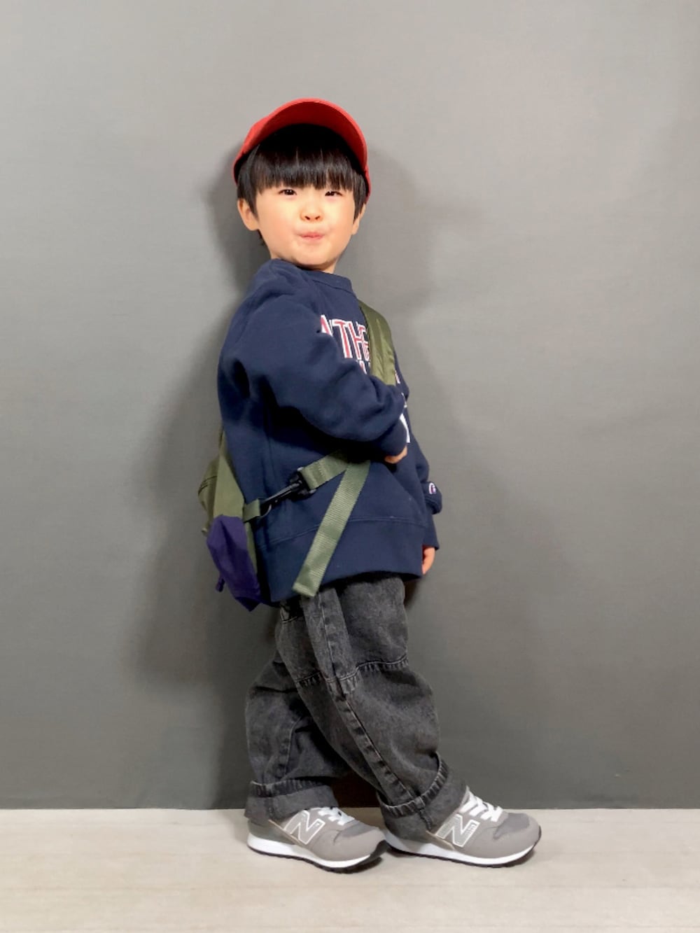 ブルー系のスウェット、ブラック系のデニムパンツ、グリーン系のボディバッグ/ウエストポーチを着用したキッズの春コーディネートの3枚目の写真