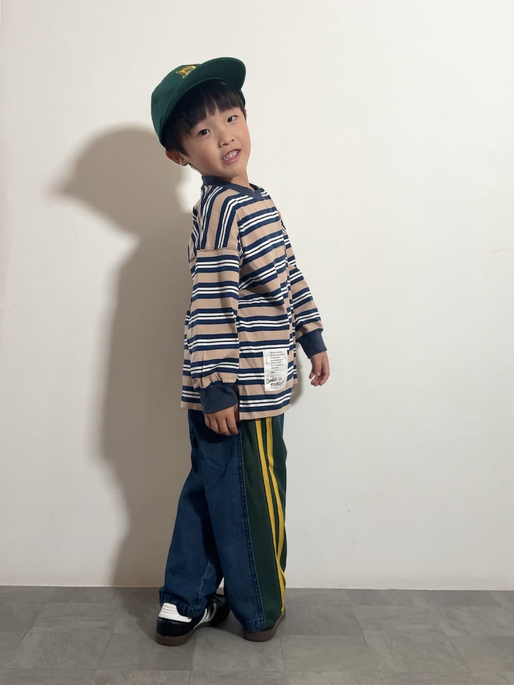 ブルー系のTシャツ/カットソー、ブルー系のデニムパンツ、ブラック系のスニーカーを着用したキッズの秋コーディネートの2枚目の写真