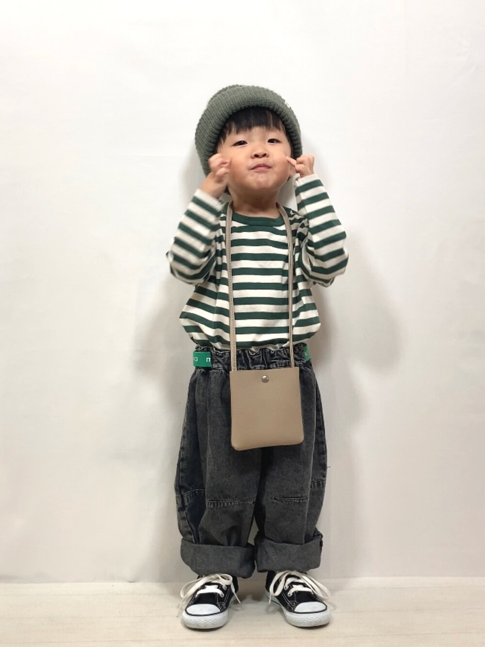 グリーン系のTシャツ/カットソー、ブラック系のデニムパンツ、ベージュ系のショルダーバッグを着用したキッズの夏コーディネートの2枚目の写真