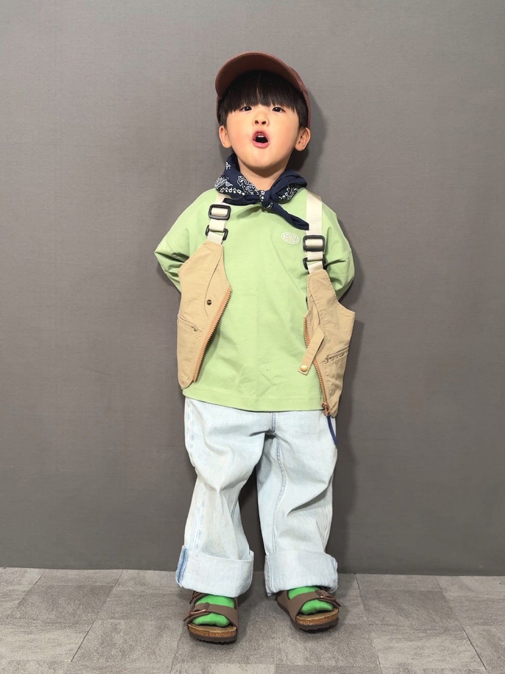 ベージュ系のベスト、グリーン系のTシャツ/カットソー、ブルー系のデニムパンツを着用したキッズの春コーディネートの5枚目の写真