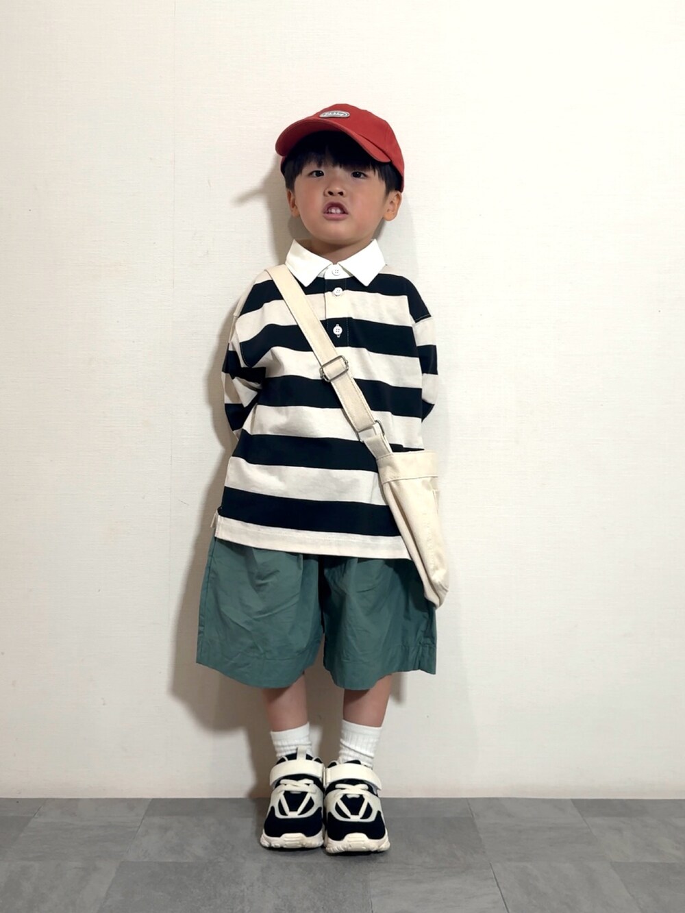 グリーン系のその他パンツ、ホワイト系のショルダーバッグ、ホワイト系のポロシャツを着用したキッズの夏コーディネートの2枚目の写真