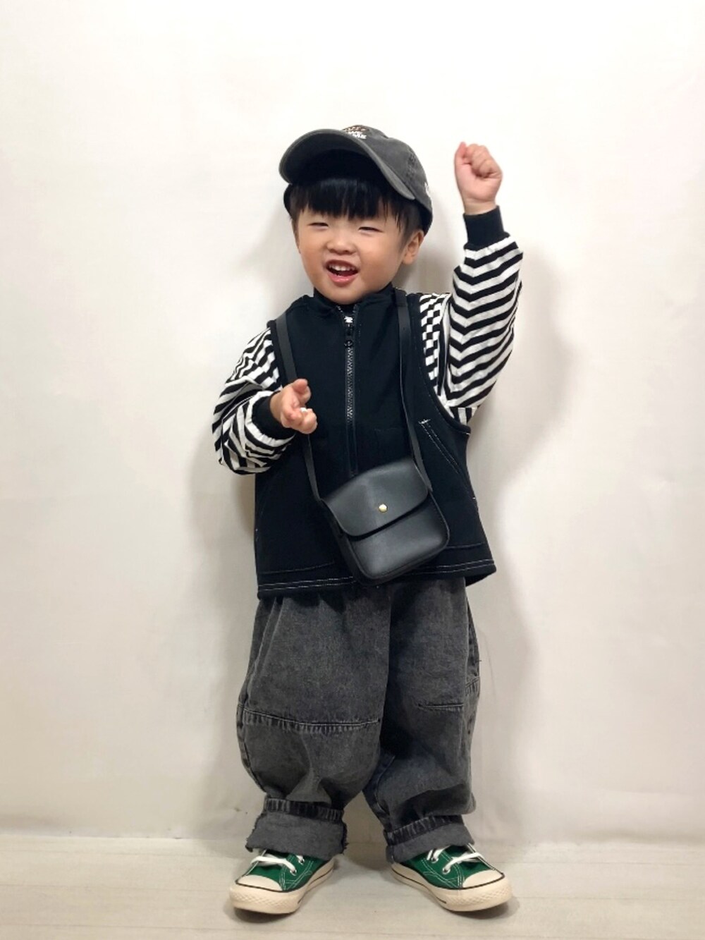 ブラック系のベスト、ブラック系のTシャツ/カットソー、ブラック系のデニムパンツを着用したキッズの秋コーディネートの4枚目の写真