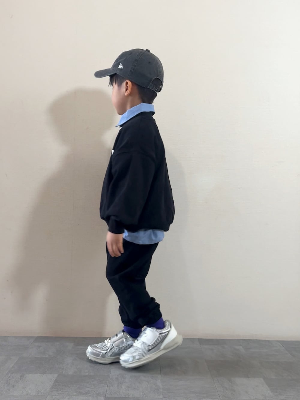 シルバー系のスニーカー、ブラック系のスウェット、ブルー系のシャツ/ブラウスを着用したキッズの秋コーディネートの3枚目の写真