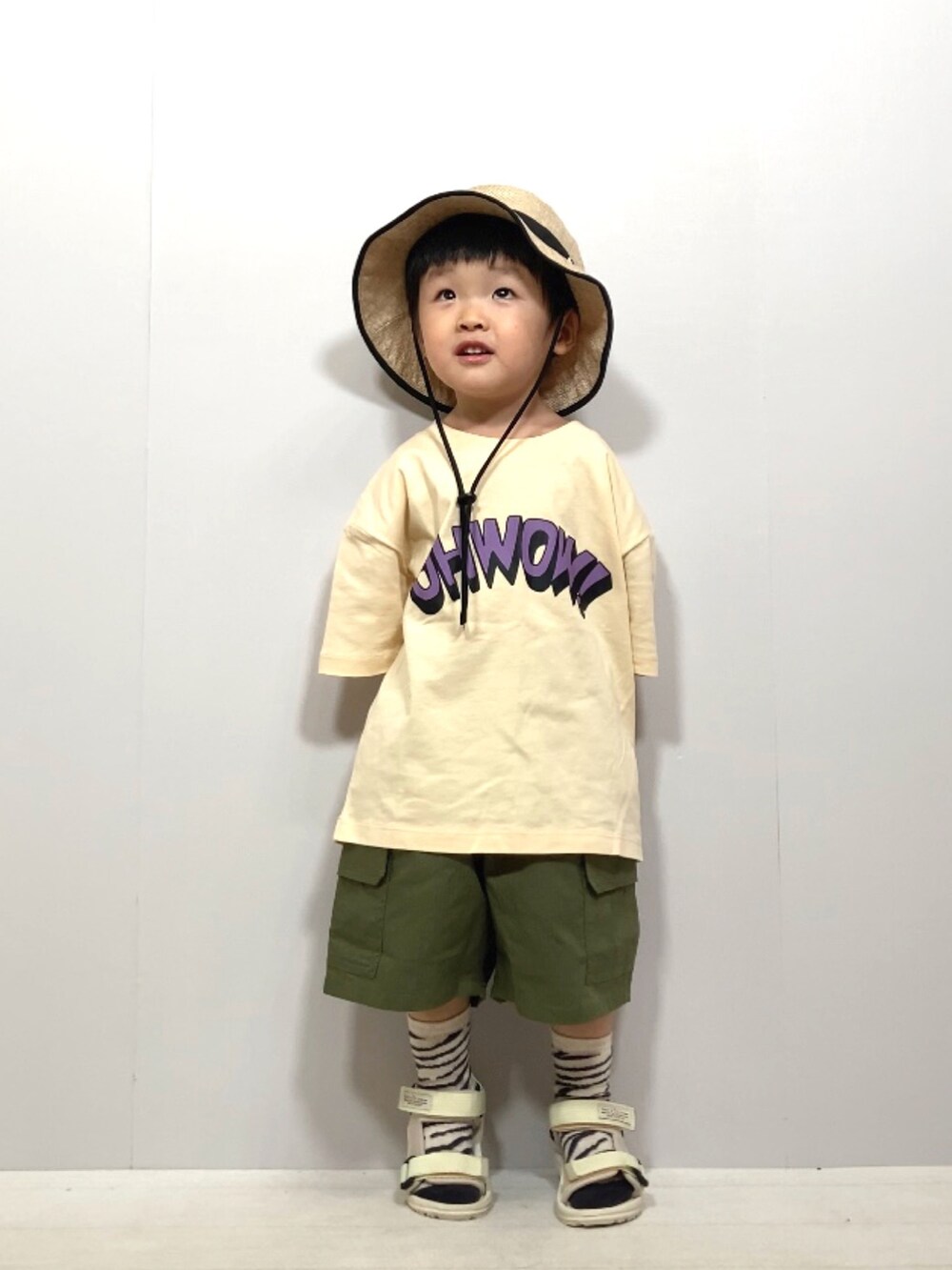 ベージュ系のTシャツ/カットソー、グリーン系のカーゴパンツ、ホワイト系のサンダルを着用したキッズの夏コーディネートの5枚目の写真