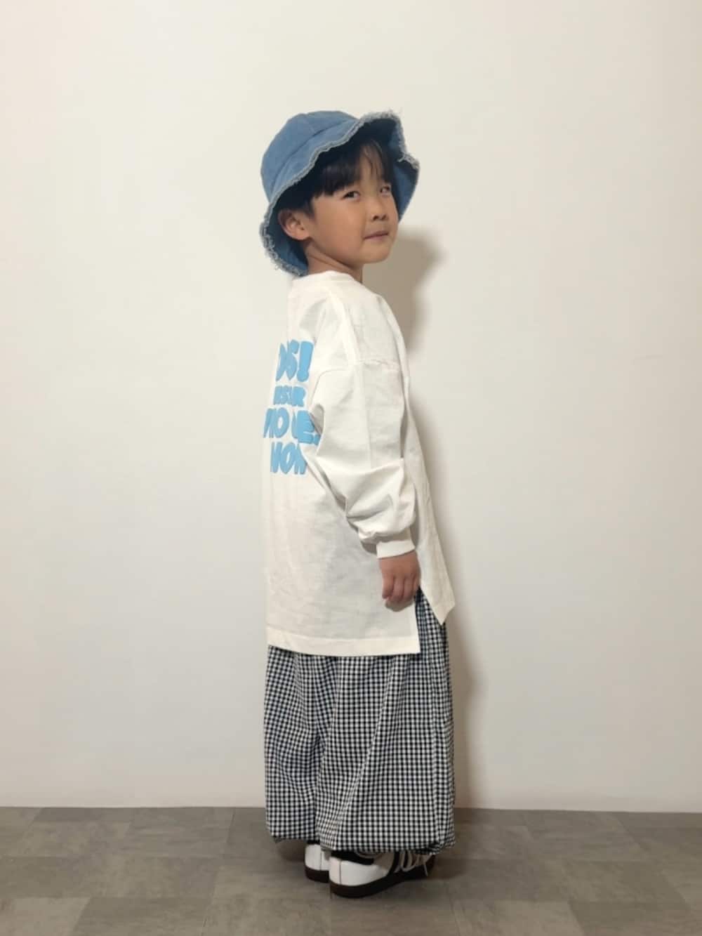 ホワイト系のTシャツ/カットソー、ブラック系のその他パンツ、ホワイト系のスニーカーを着用したキッズの春コーディネートの3枚目の写真