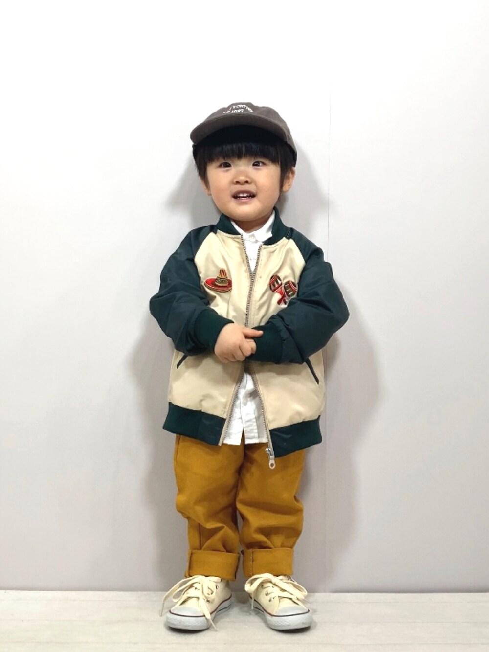 グリーン系のブルゾン、ホワイト系のシャツ/ブラウス、イエロー系のその他パンツを着用したキッズの春コーディネートの2枚目の写真