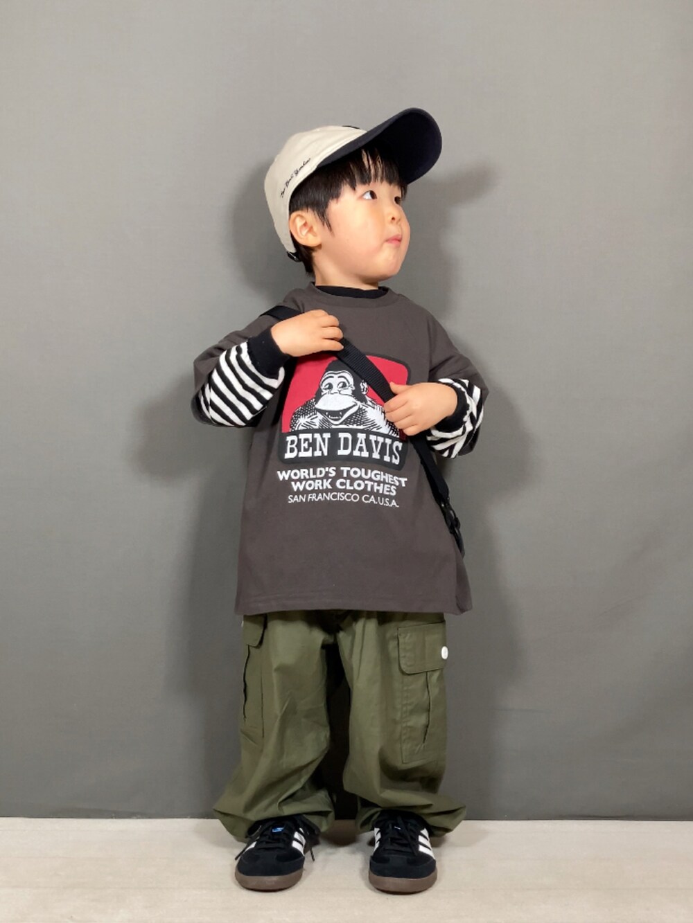 「春のNewスタイル、ボーダー、スニーカー、キャップ、ストリート、アウトドアスタイル、ショルダーバッグ、カーゴパンツ、お出かけコーデ、休日スタイル、カジュアルコーデ、スポーツミックス、春コーデ、レイヤードスタイル」｜「BEN DAVISの【BEN DAVIS】別注プリントT（100～160cm）（Tシャツ/カットソー、グレー系）」を使った、YU⭐︎さん（キッズ・90cm）の春コーディネートの2枚目の写真
