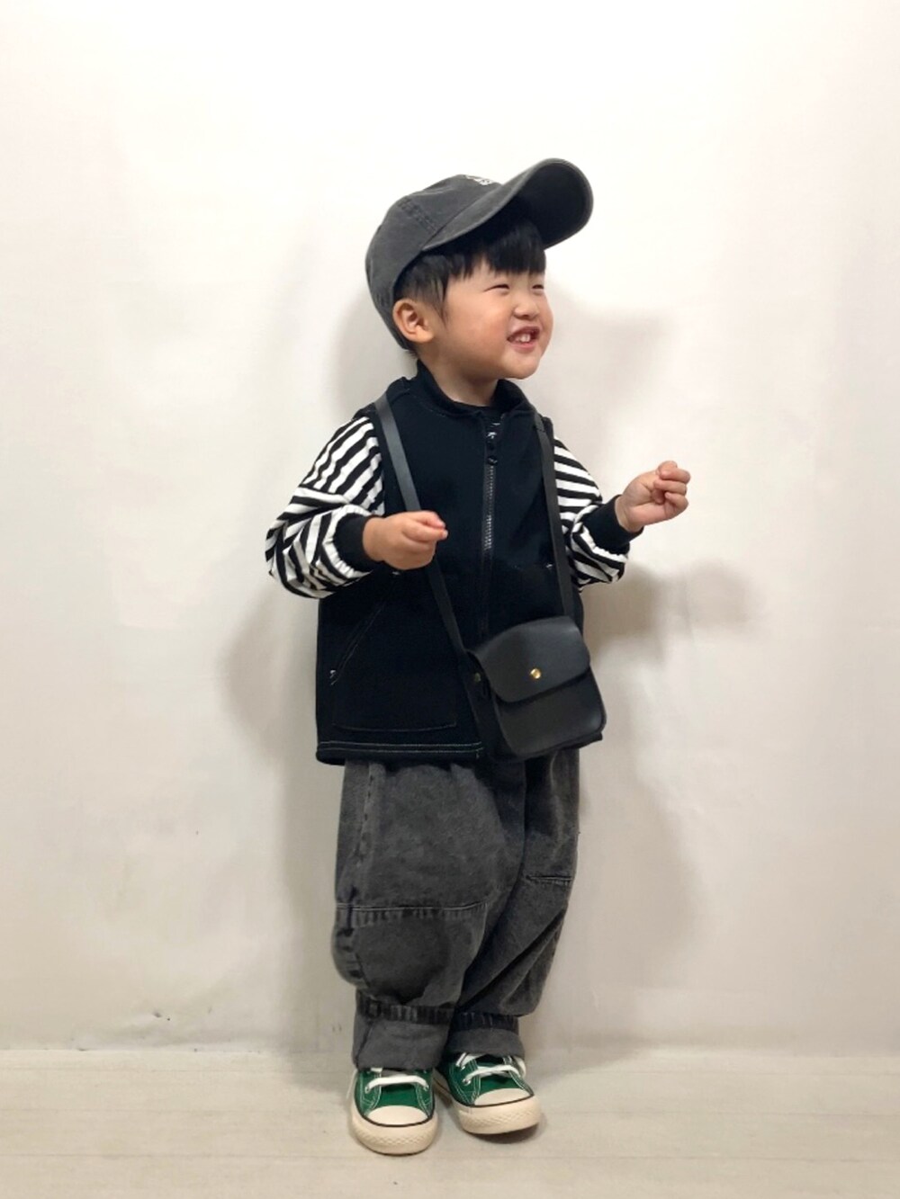 ブラック系のベスト、ブラック系のTシャツ/カットソー、ブラック系のデニムパンツを着用したキッズの秋コーディネートの3枚目の写真