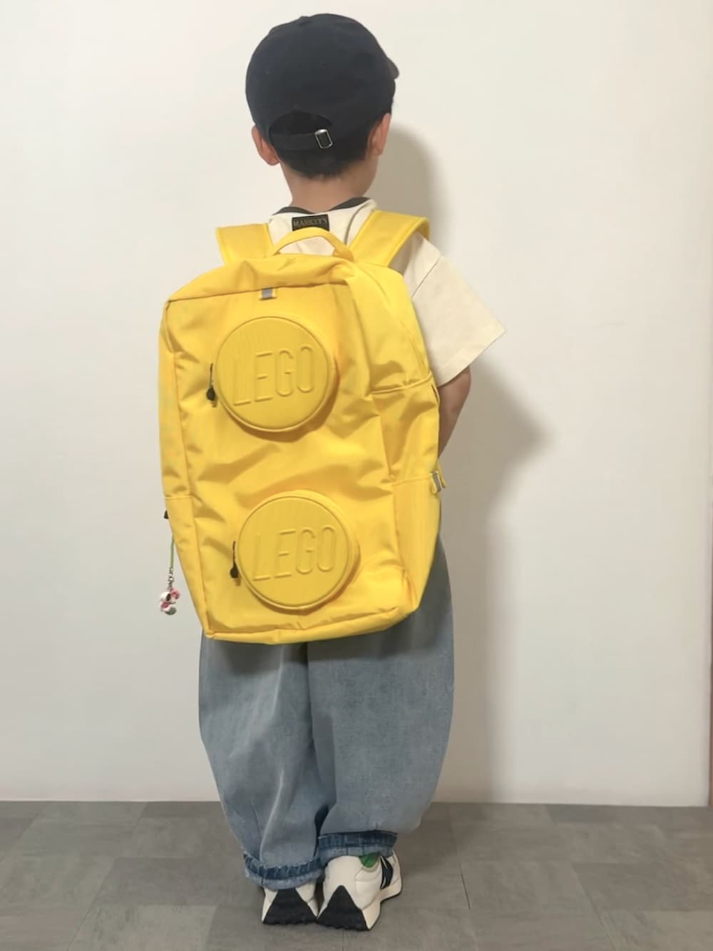 ブルー系のデニムパンツ、ホワイト系のスニーカー、ホワイト系のTシャツ/カットソーを着用したキッズの春コーディネートの3枚目の写真
