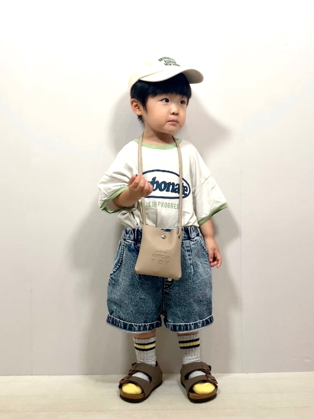 グレー系のTシャツ/カットソー、ブルー系のデニムパンツ、ベージュ系のショルダーバッグを着用したキッズの夏コーディネートの5枚目の写真