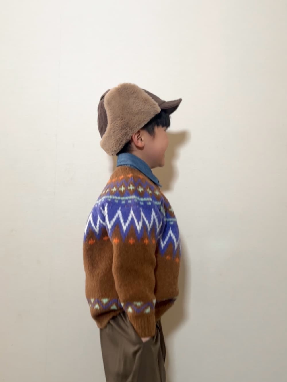 ブラウン系のニット/セーター、ブラウン系のスラックス、イエロー系のブーツを着用したキッズの冬コーディネートの4枚目の写真