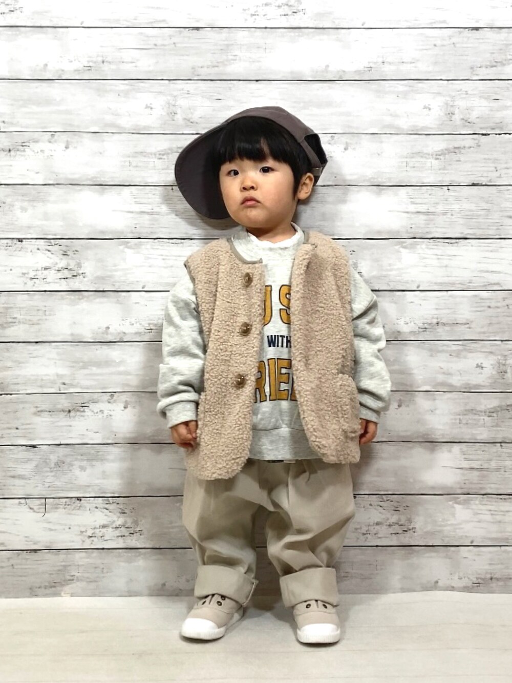 ベージュ系のベスト、ホワイト系のスウェット、グリーン系のシャツ/ブラウスを着用したキッズの冬コーディネートの2枚目の写真