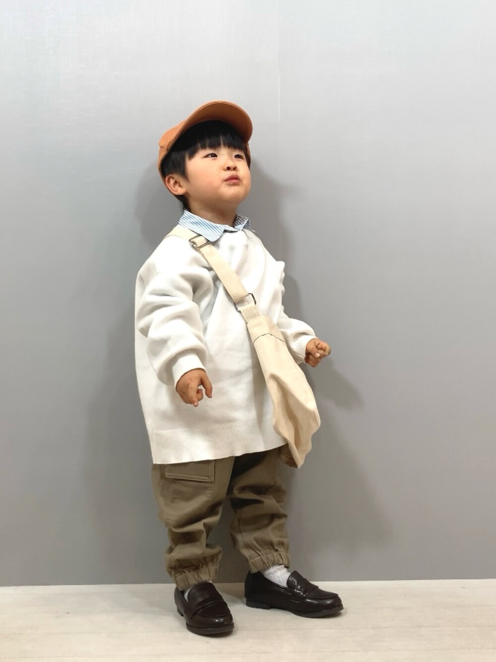 ホワイト系のニット/セーター、ブルー系のシャツ/ブラウス、ベージュ系のパンツを着用したキッズの冬コーディネートの3枚目の写真