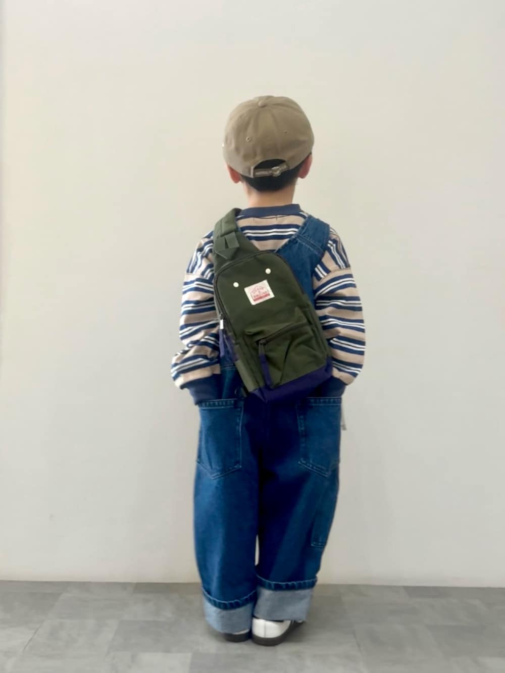 ブルー系のTシャツ/カットソー、ブルー系のサロペット/オーバーオール、グリーン系のボディバッグ/ウエストポーチを着用したキッズの春コーディネートの2枚目の写真