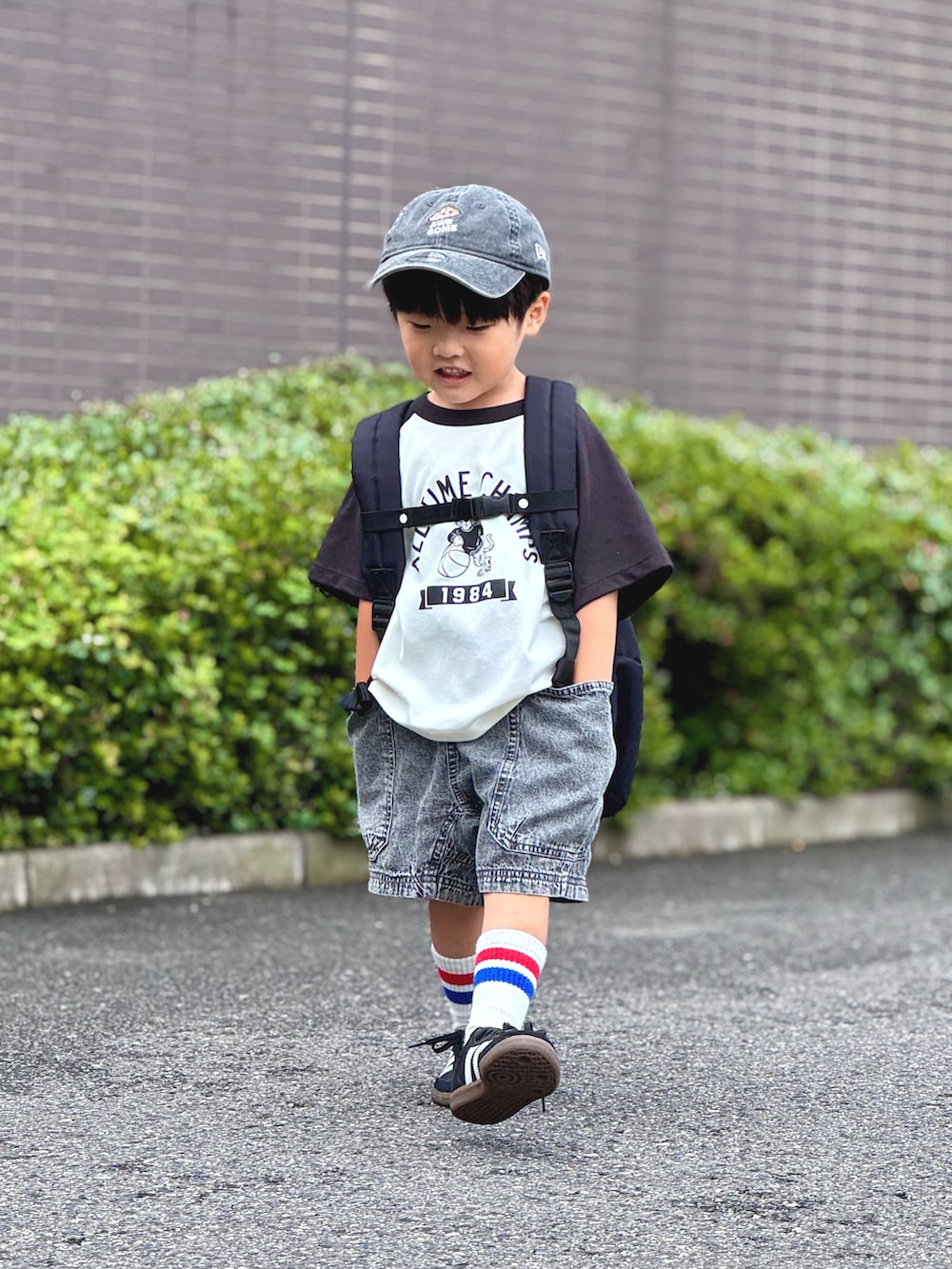 ベージュ系のTシャツ/カットソー、ブラック系のデニムパンツ、ブラック系のバックパック/リュックを着用したキッズの夏コーディネートの3枚目の写真