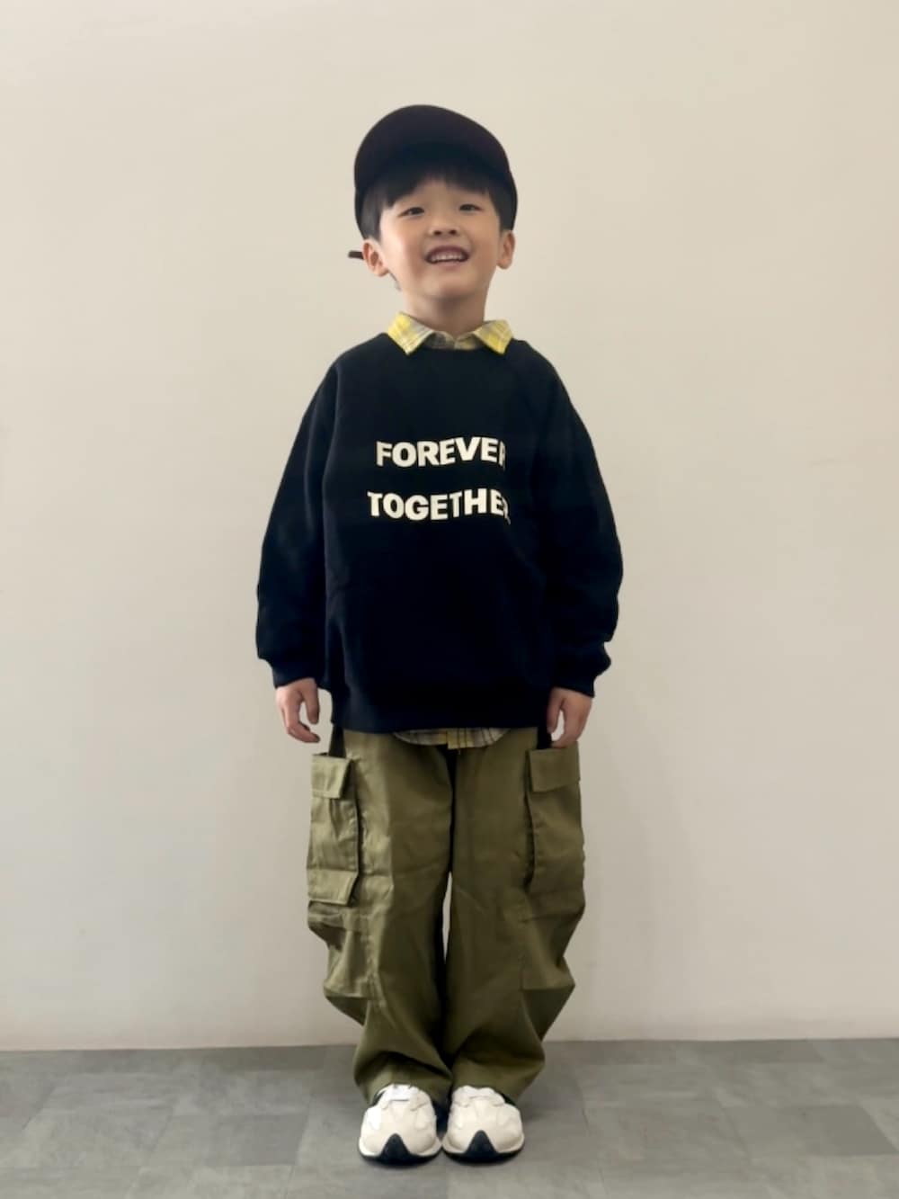 ブラック系のスウェット、イエロー系のシャツ/ブラウス、グリーン系のカーゴパンツを着用したキッズの秋コーディネートの2枚目の写真