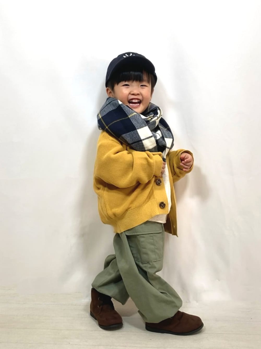 イエロー系のカーディガン/ボレロ、グレー系のスウェット、グリーン系のカーゴパンツを着用したキッズの秋コーディネートの4枚目の写真