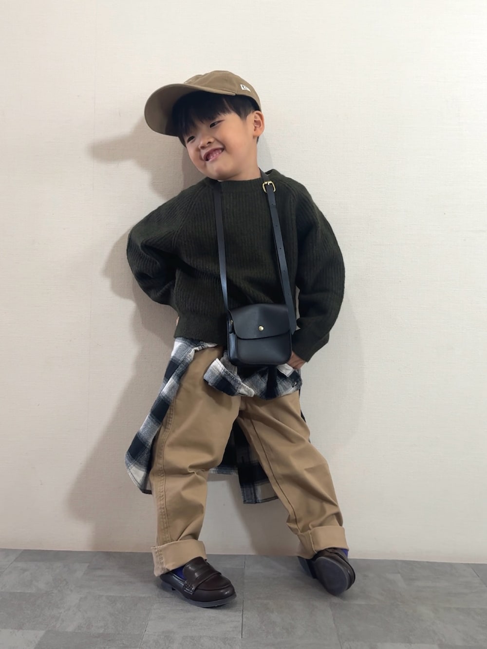 ブラウン系のローファー、グリーン系のニット/セーター、ブラック系のシャツ/ブラウスを着用したキッズの秋コーディネートの2枚目の写真