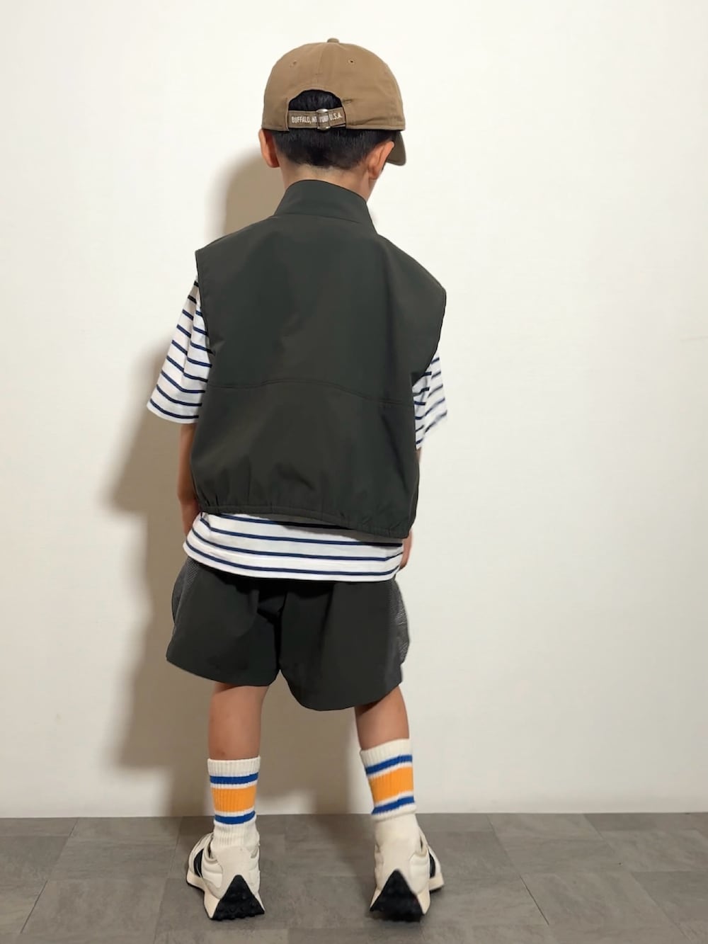 ホワイト系のスニーカー、グレー系のベスト、グレー系のその他パンツを着用したキッズの夏コーディネートの3枚目の写真