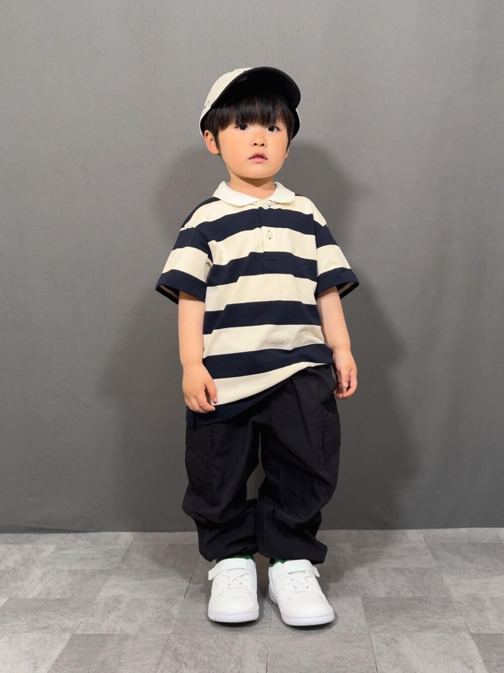 ベージュ系のトップス、ブラック系のパンツ、ホワイト系のショルダーバッグを着用したキッズの春コーディネートの4枚目の写真