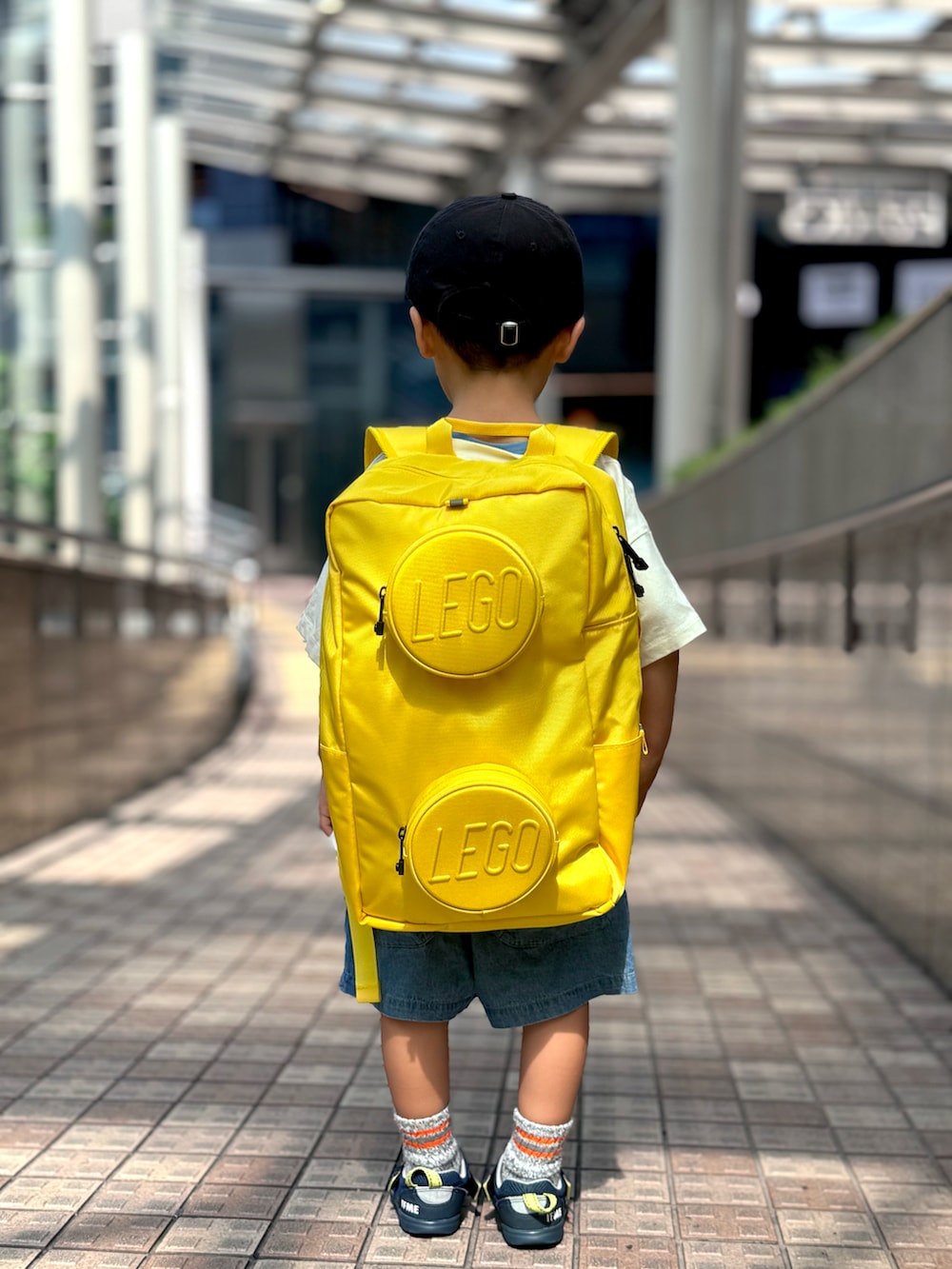 ブラック系のTシャツ/カットソー、ブルー系のその他パンツ、イエロー系のバックパック/リュックを着用したキッズの秋コーディネートの5枚目の写真