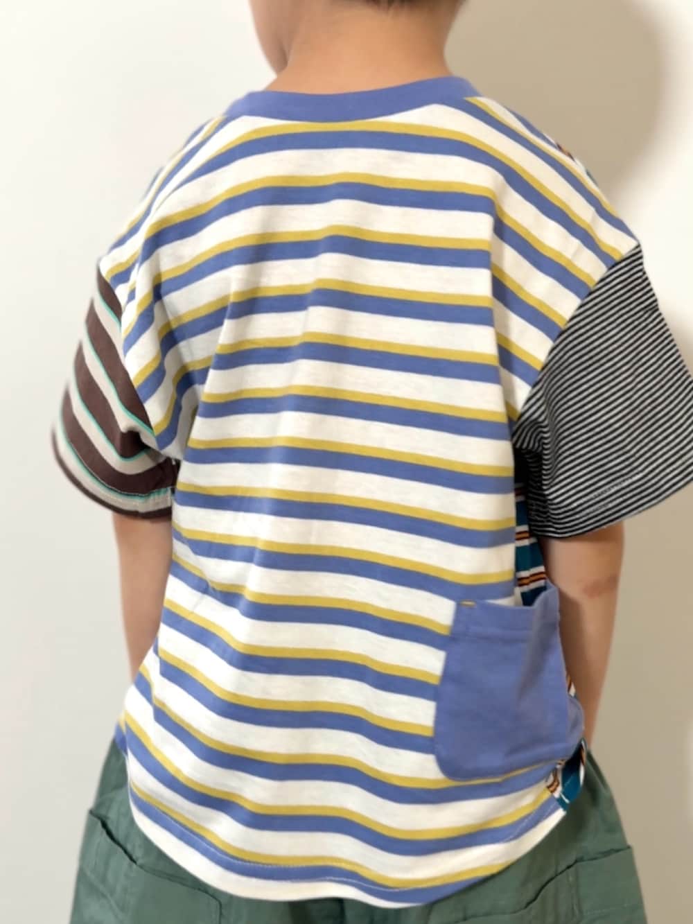グレー系のショルダーバッグ、ブラック系のスニーカー、その他のTシャツ/カットソーを着用したキッズの春コーディネートの4枚目の写真