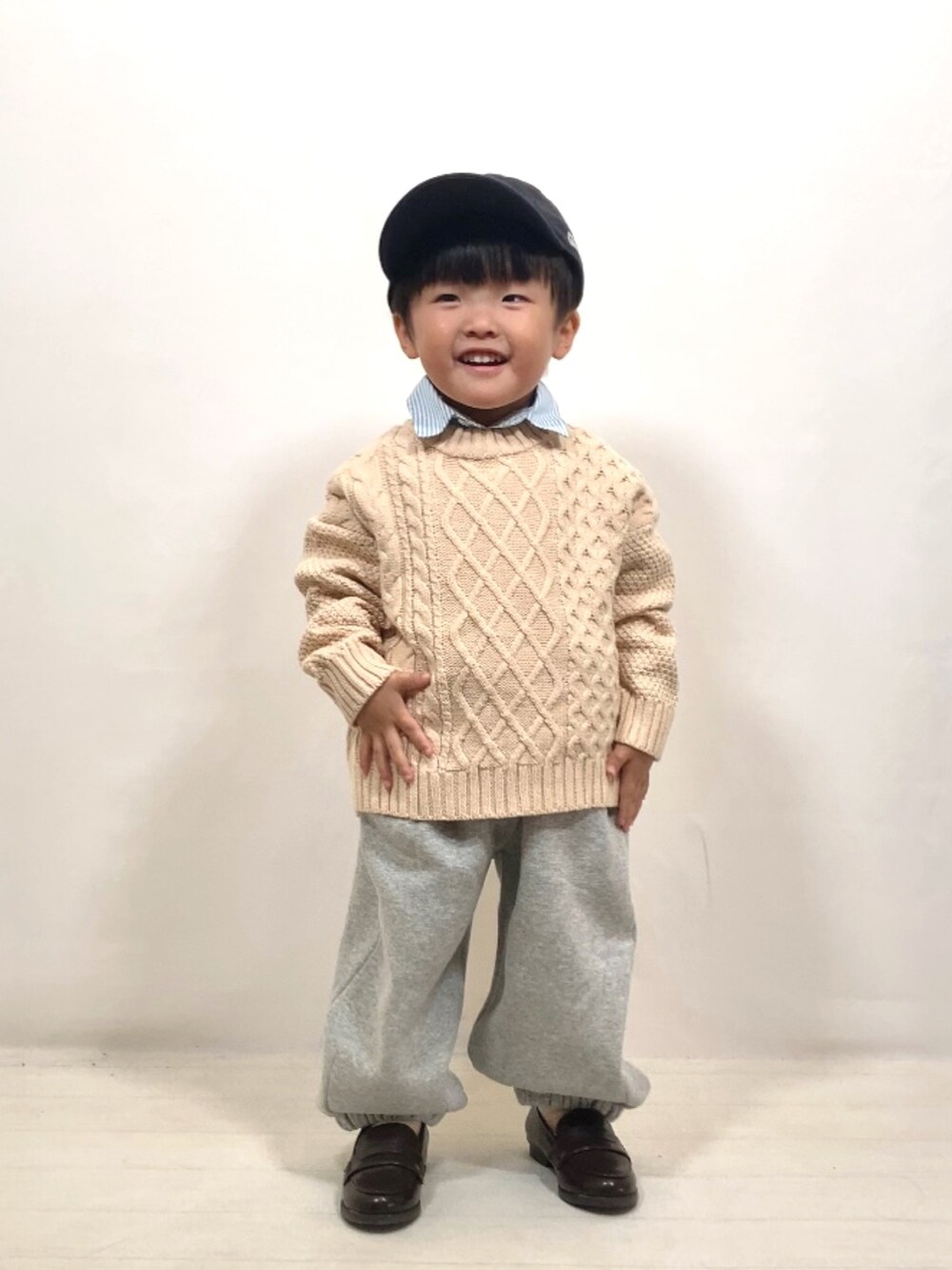 ホワイト系のニット/セーター、ブルー系のシャツ/ブラウス、グレー系のスウェットパンツを着用したキッズの秋コーディネートの3枚目の写真