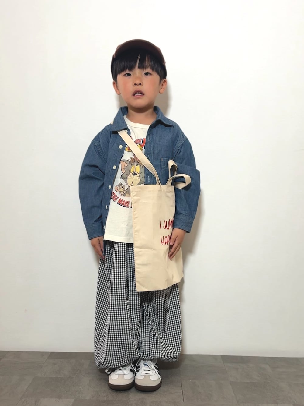 ブラック系のその他パンツ、ベージュ系のトートバッグ、ホワイト系のTシャツ/カットソーを着用したキッズの春コーディネートの3枚目の写真