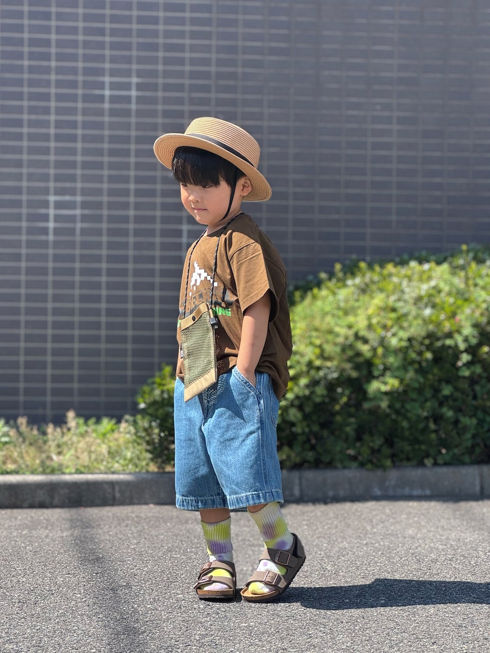 ブラウン系のサンダル、ベージュ系のショルダーバッグ、ブラウン系のTシャツ/カットソーを着用したキッズの夏コーディネートの4枚目の写真