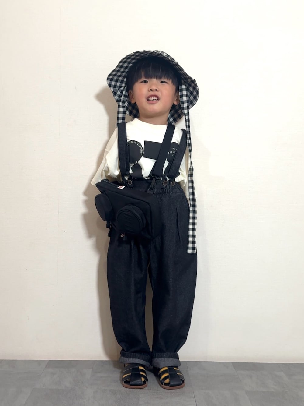 ブラック系のTシャツ/カットソー、ブラック系のサロペット/オーバーオール、ブラック系のメッセンジャーバッグを着用したキッズの夏コーディネートの3枚目の写真