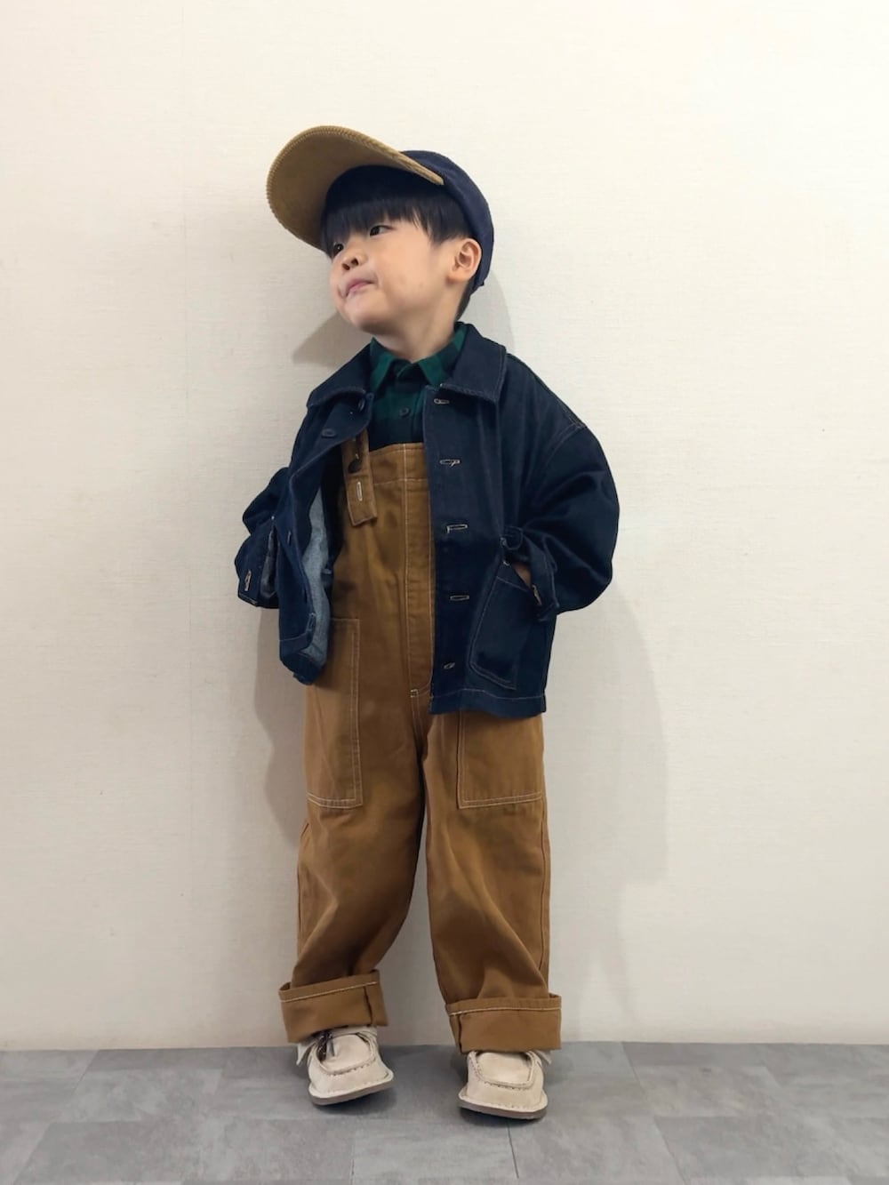 ベージュ系のモカシン/デッキシューズ、グリーン系のシャツ/ブラウス、ブルー系のデニムジャケットを着用したキッズの秋コーディネートの3枚目の写真