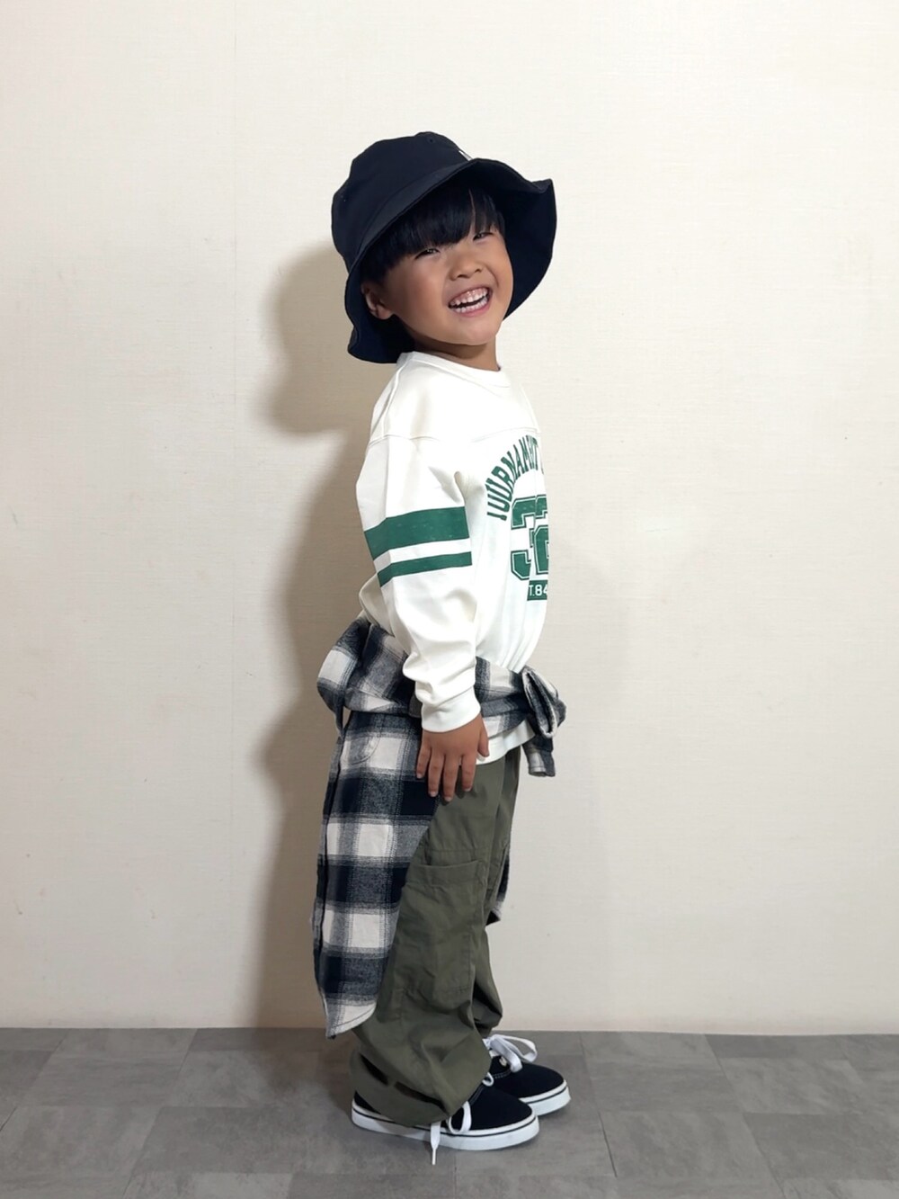 ブラック系のスニーカー、グリーン系のカーゴパンツ、ホワイト系のトップスを着用したキッズの夏コーディネートの4枚目の写真