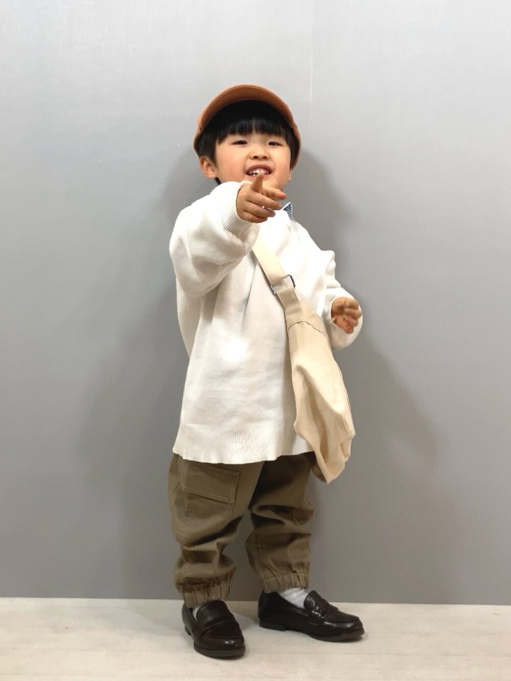 ホワイト系のニット/セーター、ブルー系のシャツ/ブラウス、ベージュ系のパンツを着用したキッズの冬コーディネートの5枚目の写真