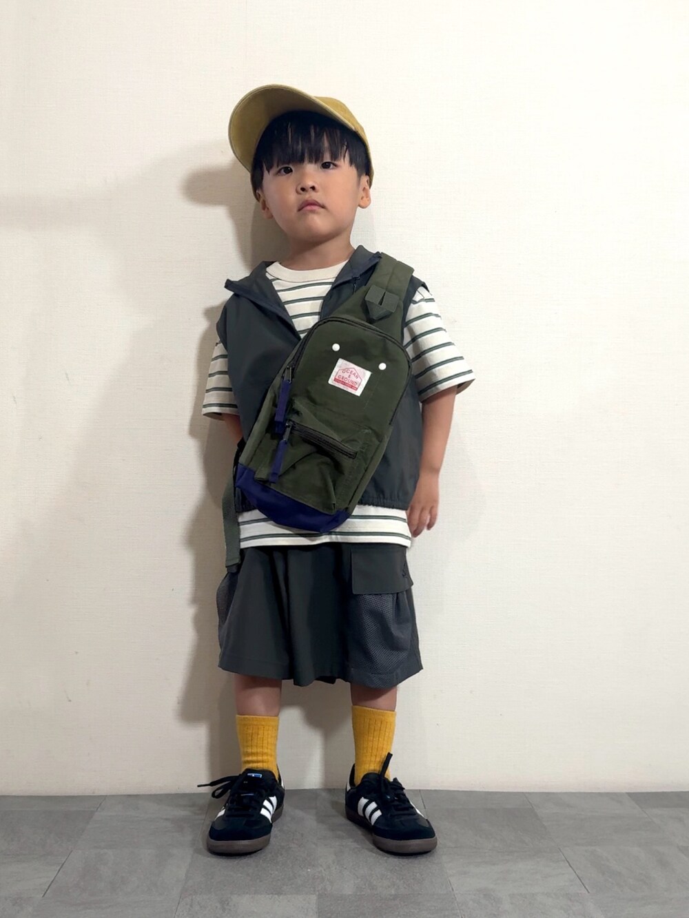 グレー系のベスト、グレー系のその他パンツ、ブラック系のスニーカーを着用したキッズの夏コーディネートの3枚目の写真