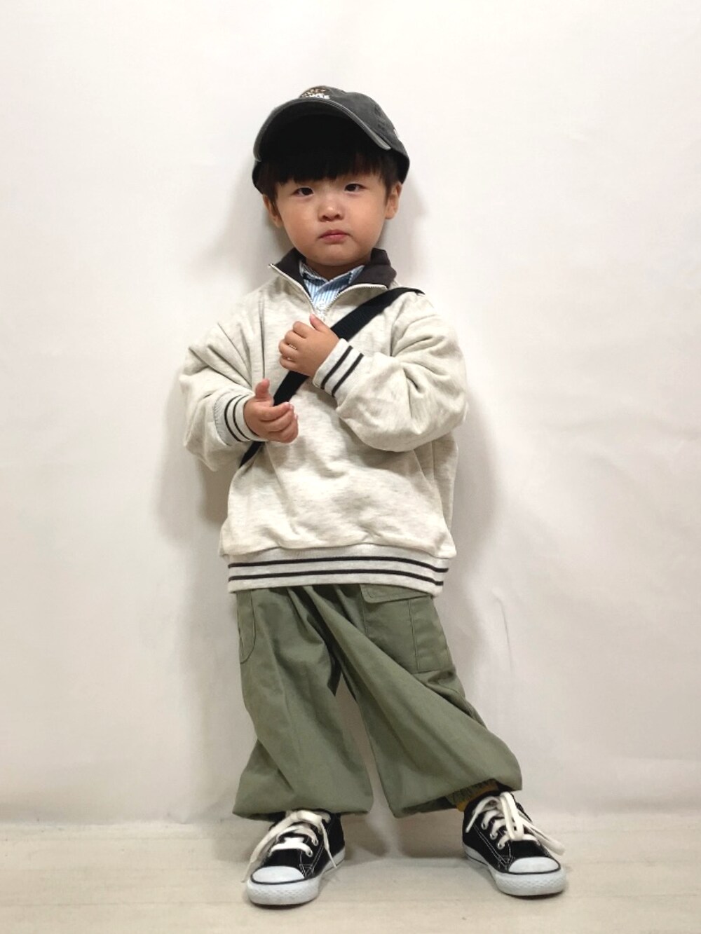 ベージュ系のスウェット、ブルー系のシャツ/ブラウス、グリーン系のカーゴパンツを着用したキッズの秋コーディネートの3枚目の写真