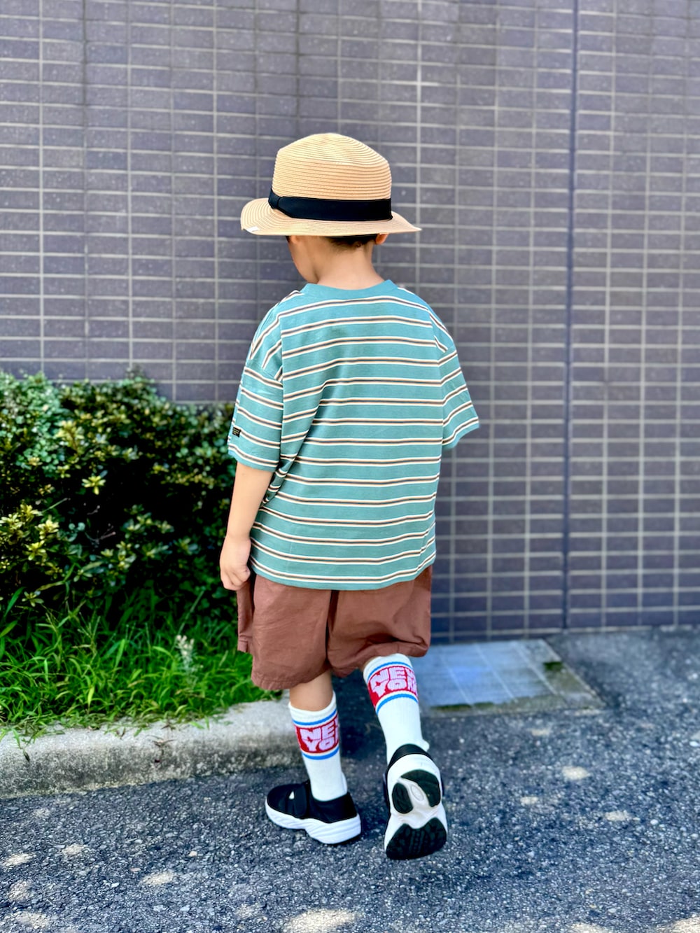 ブラウン系のその他パンツ、グリーン系のTシャツ/カットソー、ブラック系のサンダルを着用したキッズの夏コーディネートの2枚目の写真