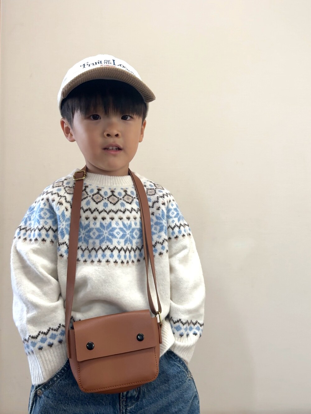 ブルー系のデニムパンツ、イエロー系のブーツ、ホワイト系のニット/セーターを着用したキッズの秋コーディネートの5枚目の写真