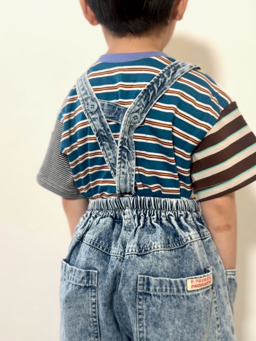 シルバー系のスニーカー、その他のTシャツ/カットソー、ブルー系のデニムパンツを着用したキッズの春コーディネートの4枚目の写真