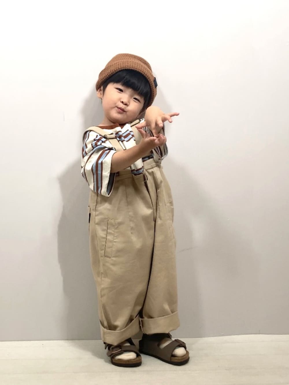 ベージュ系のTシャツ/カットソー、ベージュ系のサロペット/オーバーオール、ブラウン系のサンダルを着用したキッズの夏コーディネートの4枚目の写真