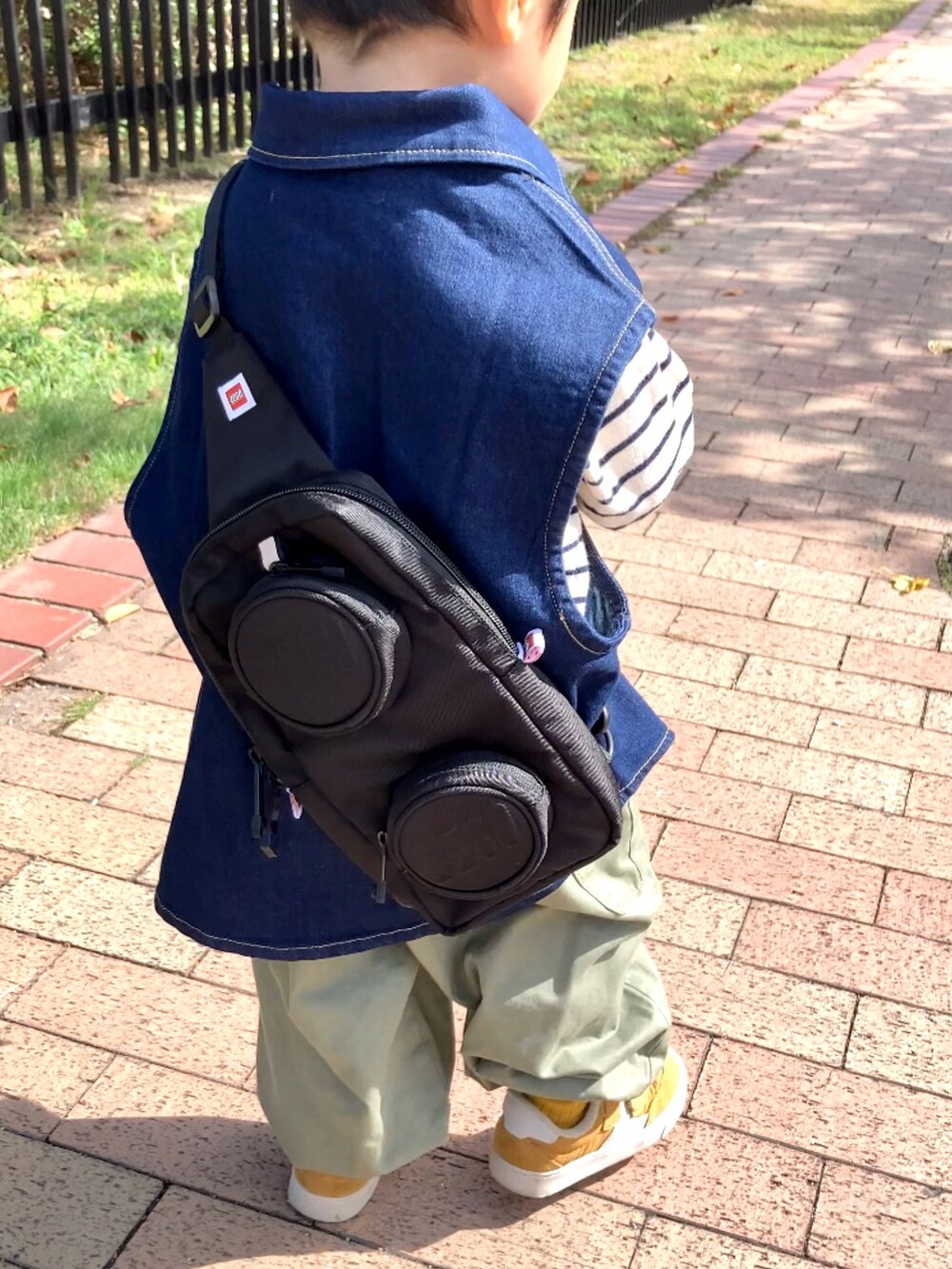 ブルー系のベスト、ホワイト系のTシャツ/カットソー、グリーン系のカーゴパンツを着用したキッズの秋コーディネートの4枚目の写真