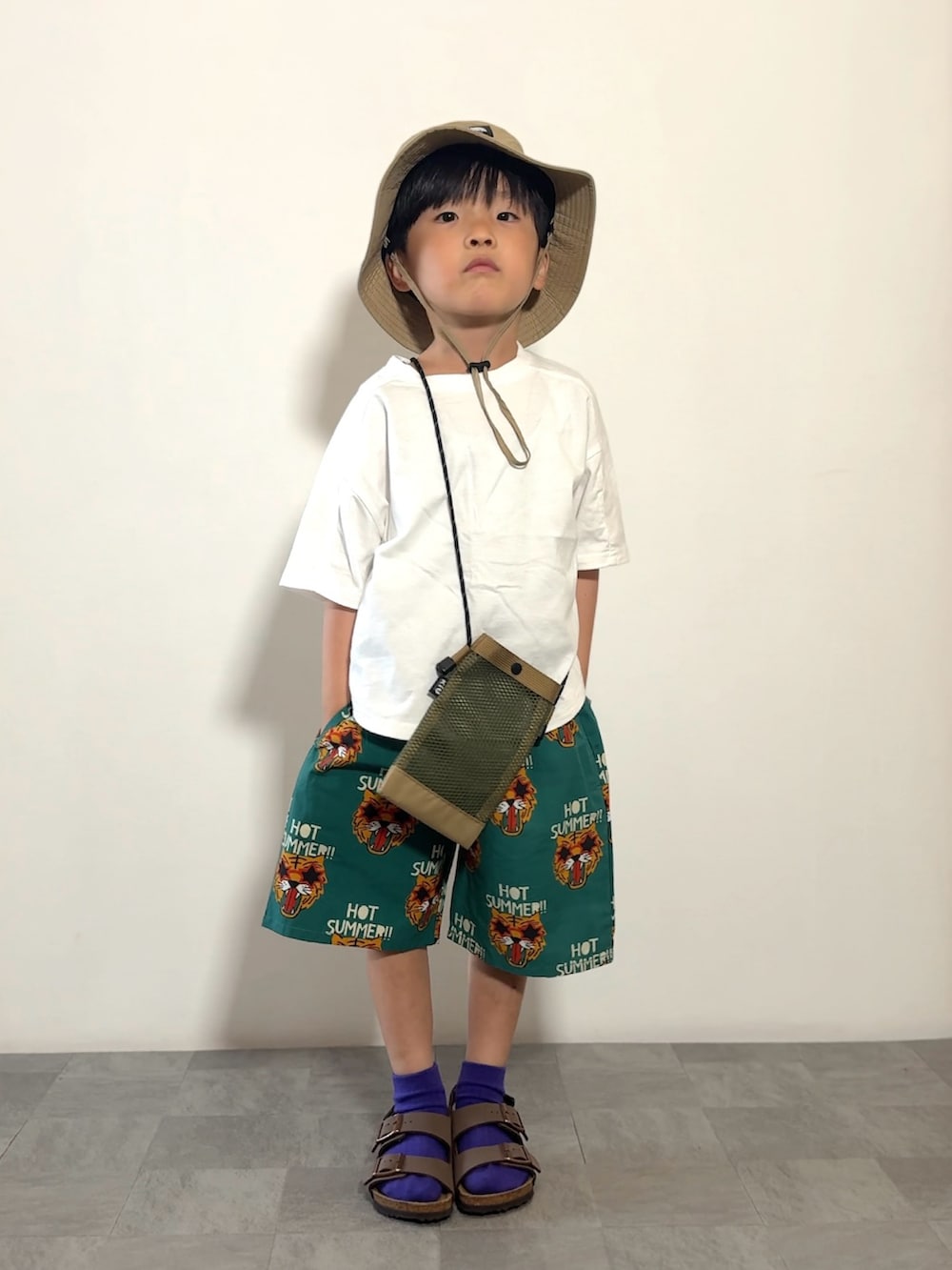 ホワイト系のTシャツ/カットソー、グリーン系のその他パンツ、ブラウン系のサンダルを着用したキッズの春コーディネートの2枚目の写真