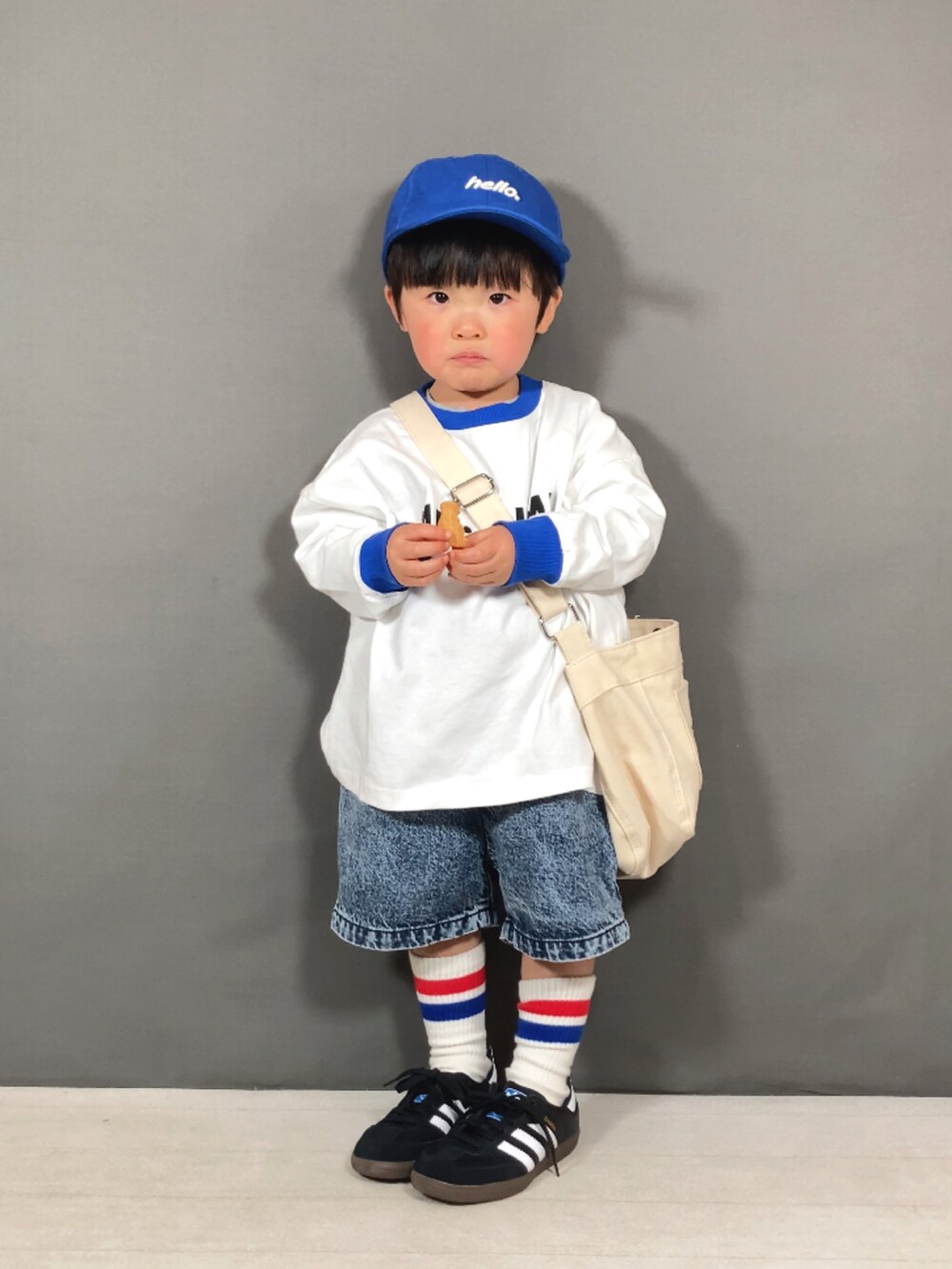 ブルー系のTシャツ/カットソー、ブルー系のデニムパンツ、ホワイト系のショルダーバッグを着用したキッズの春コーディネートの2枚目の写真