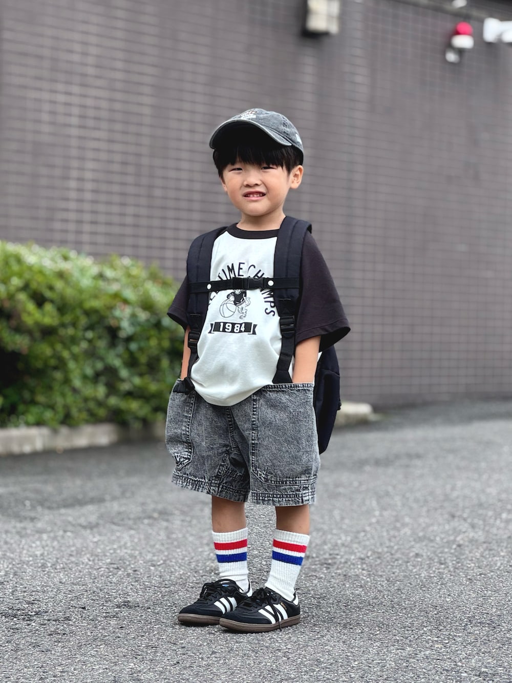 ベージュ系のTシャツ/カットソー、ブラック系のデニムパンツ、ブラック系のバックパック/リュックを着用したキッズの夏コーディネートの2枚目の写真