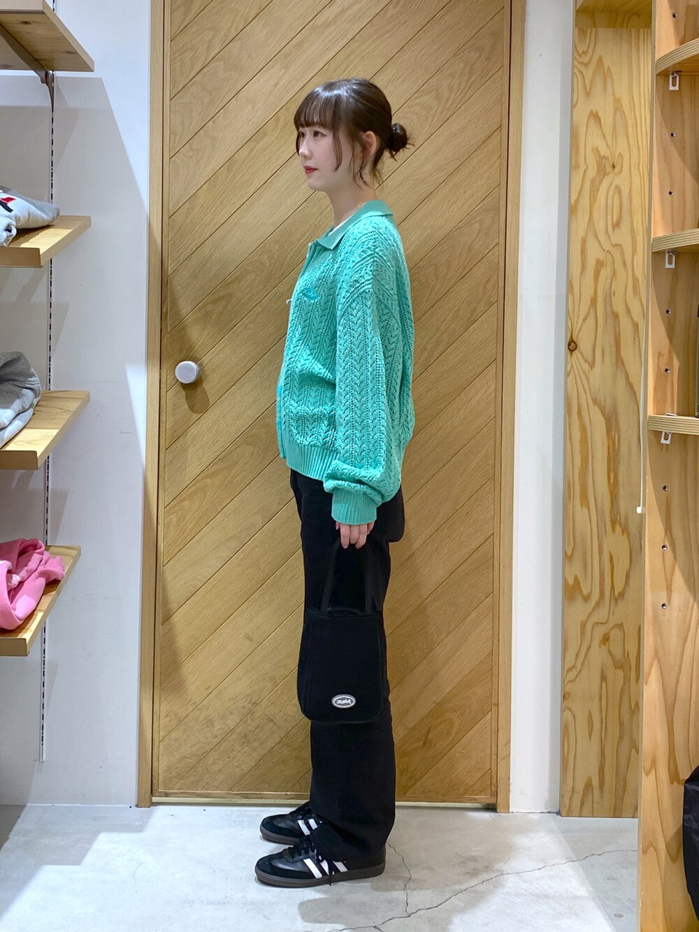 ブラック系のショルダーバッグ、グリーン系のカーディガン/ボレロ、ホワイト系のTシャツ/カットソーを着用したレディースの春コーディネートの2枚目の写真