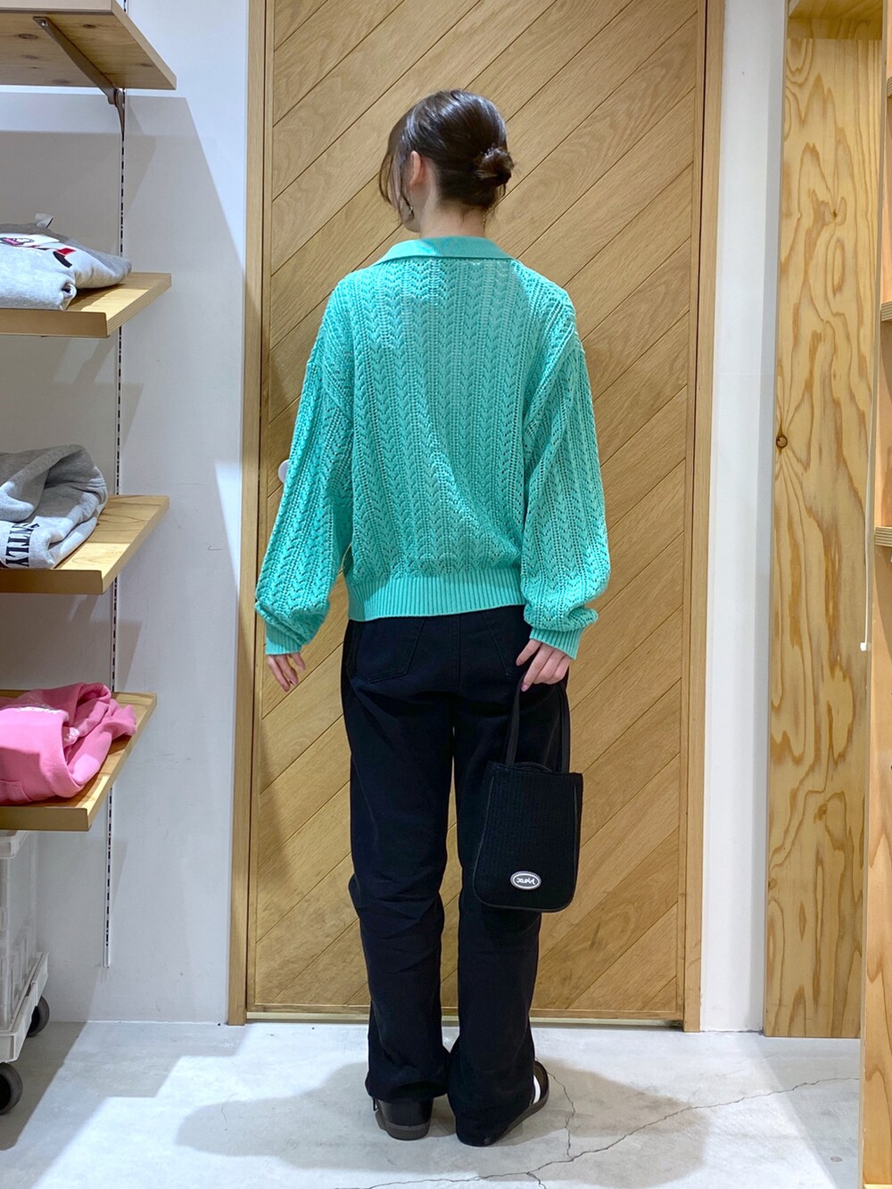 ブラック系のショルダーバッグ、グリーン系のカーディガン/ボレロ、ホワイト系のTシャツ/カットソーを着用したレディースの春コーディネートの3枚目の写真